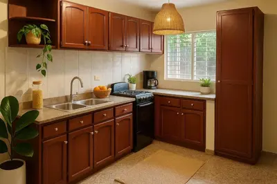 a kitchen with wooden cabinets and a sink at Relaxing and Serene Guest Room in Cancino