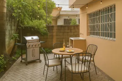 a patio with a table and chairs and a grill at Relaxing and Serene Guest Room in Cancino