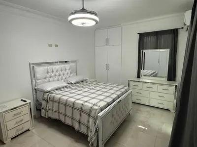 a white bedroom with a bed and a mirror at Modern Getaway with Private Pool, Montecristi in Villa Vásquez