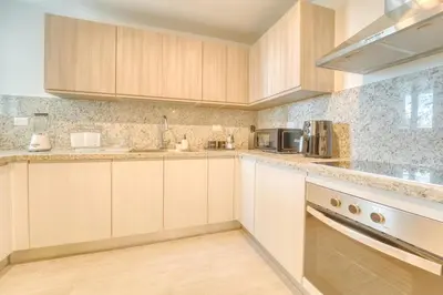 a kitchen with wooden cabinets and a counter top at Luxury apartment in hard rock punta cana in Punta Cana