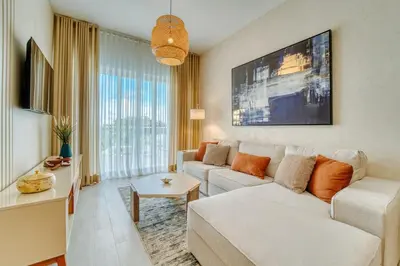 a living room with a white couch and a large window at Luxury apartment in hard rock punta cana in Punta Cana