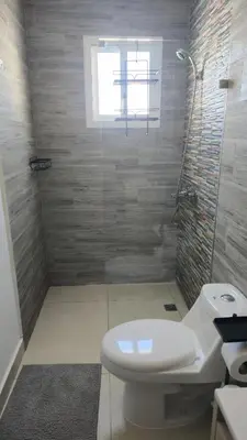 a bathroom with a white toilet and a window at Nuevo Apartamento en Bayahibe in Bayahibe