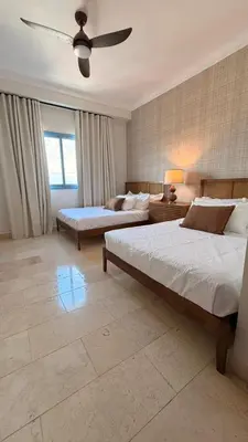 a bedroom with two beds and a ceiling fan at Family Friendly Beach Apartment in Juan Dolio in Los Corrales