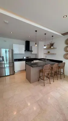 a kitchen with a table and chairs and a refrigerator at Family Friendly Beach Apartment in Juan Dolio in Los Corrales