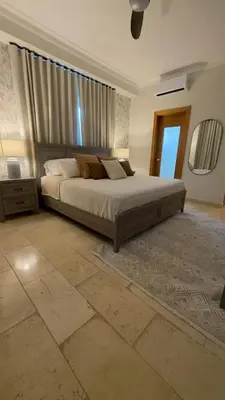 a bedroom with a large bed and a large window at Family Friendly Beach Apartment in Juan Dolio in Los Corrales