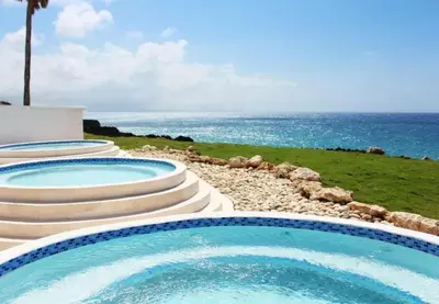 two swimming pools with the ocean in the background at Bubble Glamping, Family 2 beds, we have a 12 units like this in Sosúa