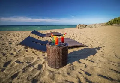 a table on the beach with drinks on it at Bubble Glamping, Family 2 beds, we have a 12 units like this in Sosúa