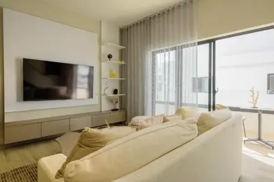 a living room with a white couch and a tv at Ático ONA White Sands | Terraza & Picuzzi privado in Punta Cana