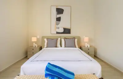 a bedroom with a large white bed with two lamps at Ático ONA White Sands | Terraza & Picuzzi privado in Punta Cana