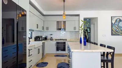 a kitchen with white cabinets and a large island at Sosua Ocean Village - Villas Marinas 27B in Sosúa