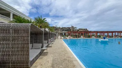 a swimming pool with chaise lounge chairs next to a resort at Sosua Ocean Village - Villas Marinas 27B in Sosúa