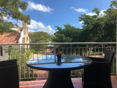 a glass table with a vase on it on a balcony at Cadaques Bayahibe Family Apts in Bayahibe