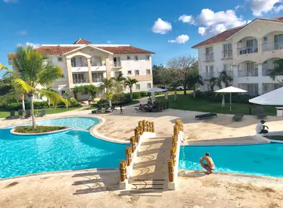 a man in a pool at a resort at Cadaques Bayahibe Family Apts in Bayahibe