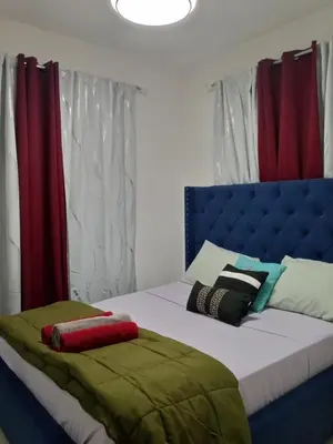 a bedroom with a bed with a blue headboard at Elton de Gurabo es tu lugar in Santiago de los Caballeros