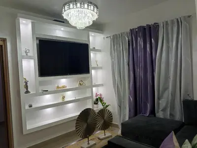 a living room with a tv and a chandelier at Elton de Gurabo es tu lugar in Santiago de los Caballeros