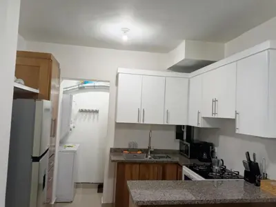 a kitchen with white cabinets and a counter top at Elton de Gurabo es tu lugar in Santiago de los Caballeros