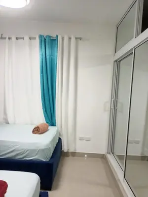 a small room with two beds and a window at Elton de Gurabo es tu lugar in Santiago de los Caballeros