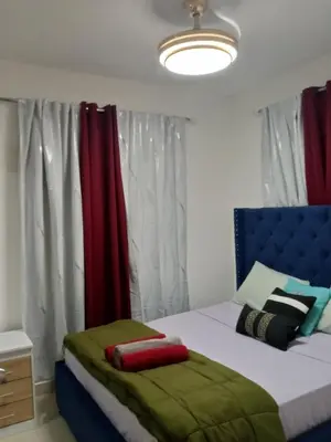 a bedroom with a bed with a blue headboard at Elton de Gurabo es tu lugar in Santiago de los Caballeros