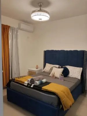 a bed with a blue headboard in a room at Elton de Gurabo es tu lugar in Santiago de los Caballeros