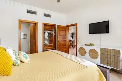 a bedroom with a large bed with a flat screen tv at Beautiful 2 bedroom apartment on the beach in Punta Cana