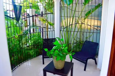 a porch with two chairs and a potted plant at Casa Bayaguana Real in Bayaguana