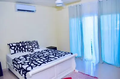 a bedroom with a large bed with blue curtains at Casa Bayaguana Real in Bayaguana