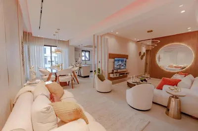 a living room with white furniture and a dining room at Luxstay SDQ in Santo Domingo