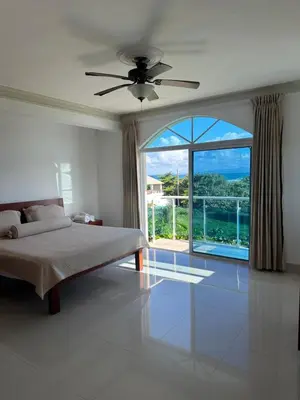 a bedroom with a bed and a large window at Cabarete Town House in Cabarete