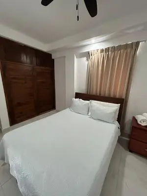 a bedroom with a white bed and a window at Cabarete Town House in Cabarete
