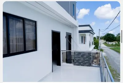 a white house with a balcony with a black door at Villa Joa in Punta Cana