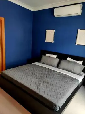 a blue bedroom with a bed with a blue wall at Miraculus Penthouse With Private Jacuzzi in Santo Domingo