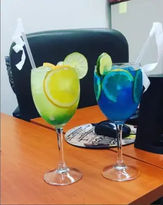 two glasses with lime and blue drinks on a table at Hotel Novus Caoba, Confort y calidez en Mao, Valverde