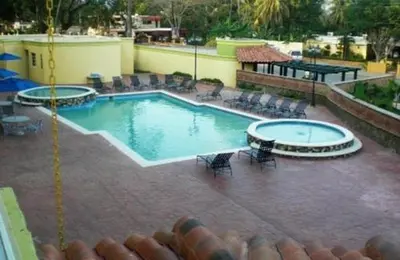 a large swimming pool with chairs and a table at Hotel Novus Caoba, Confort y calidez en Mao, Valverde