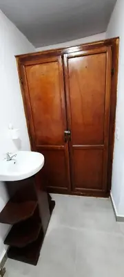a bathroom with a wooden cabinet next to a sink at Puerto Plata Home in San Felipe de Puerto Plata