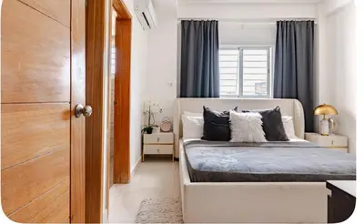 a bedroom with a bed with black and white pillows at Un bonito amanecer in Santo Domingo
