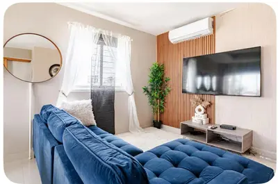a living room with a blue couch and a tv at Un bonito amanecer in Santo Domingo