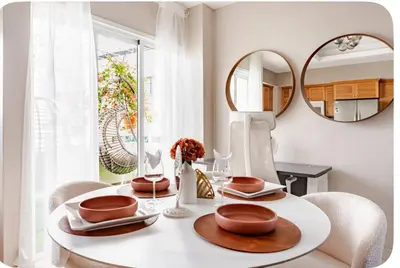 a dining room with a table with chairs and a mirror at Un bonito amanecer in Santo Domingo