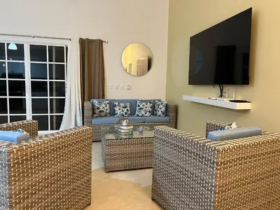 a living room with two couches and a flat screen tv at Villa 156, 3 bedrooms and 3 bathrooms with private pool in Sosúa