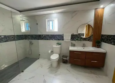 a bathroom with a toilet and a sink and a shower at Villa Lujosa en Boca Chica in Cuevas