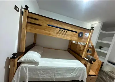 a bedroom with a wooden bunk bed with white sheets at Villa Lujosa en Boca Chica in Cuevas