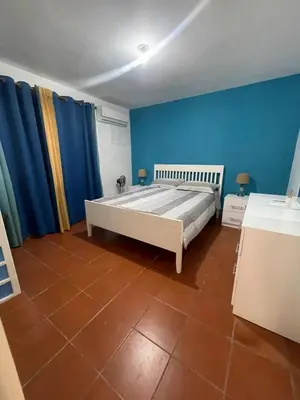 a bedroom with a bed with blue walls and a tile floor at Residencial flor Betania in San Pedro de Macorís