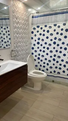 a bathroom with a toilet and a shower curtain at Residencial flor Betania in San Pedro de Macorís