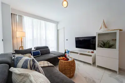 a living room with a couch and a flat screen tv at Vista Relax Golf & Pool View @ Cana Rock Star 210 in Punta Cana