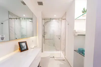 a white bathroom with a shower and a toilet at Vista Relax Golf & Pool View @ Cana Rock Star 210 in Punta Cana