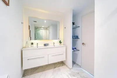 a white bathroom with a sink and a mirror at Vista Relax Golf & Pool View @ Cana Rock Star 210 in Punta Cana