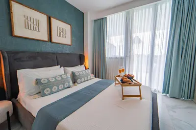 a bedroom with a bed with blue walls and a window at Vista Jade Apartamento 2 Hab Vista Picina y Golf in Punta Cana