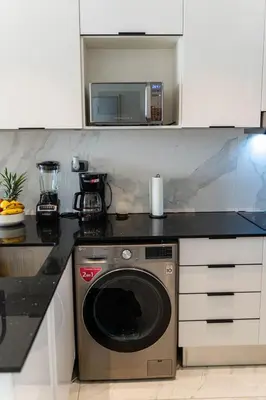 a kitchen with a microwave and a washing machine at Vista Jade Apartamento 2 Hab Vista Picina y Golf in Punta Cana