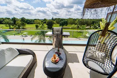 a balcony with a table with a bowl of food on it at Vista Jade Apartamento 2 Hab Vista Picina y Golf in Punta Cana