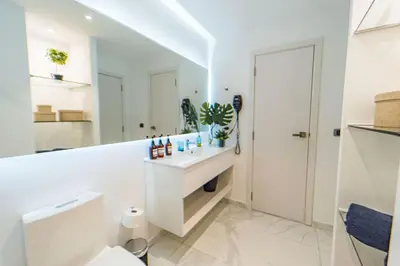 a white bathroom with a sink and a toilet at Vista Jade Apartamento 2 Hab Vista Picina y Golf in Punta Cana