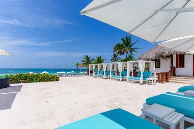 a row of chairs and umbrellas on the beach at Vista Jade Apartamento 2 Hab Vista Picina y Golf in Punta Cana